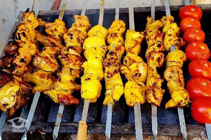 مراحل مزه‌دار کردن جوجه کباب با زعفران دم کرده غلیظ، پیاز خلالی و ادویه‌های مخصوص در یک ظرف شیشه‌ای